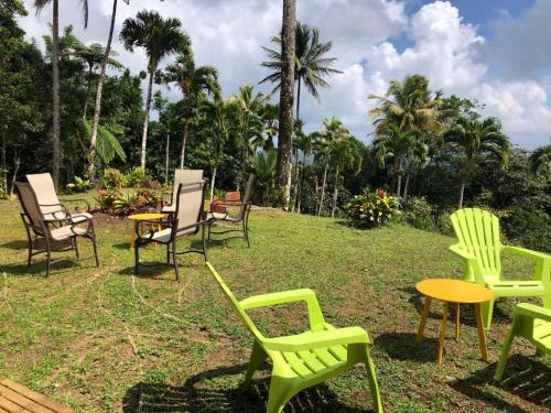 a group of chairs and tables in the grass at La villa Gevyrolaine in Gros-Morne