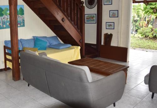 a living room with a couch and a bed at La villa Gevyrolaine in Gros-Morne