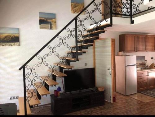 sala de estar con escalera y TV de pantalla plana en Holiday cottage-vakantiehuis-vikendica, en Zolaći