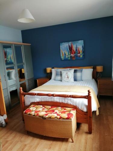 a bedroom with a bed with a ottoman in front of it at Lynn's Lodge, International Airport 15mins in Randalstown