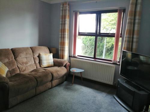 a living room with a couch and a television at Lynn's Lodge in Randalstown