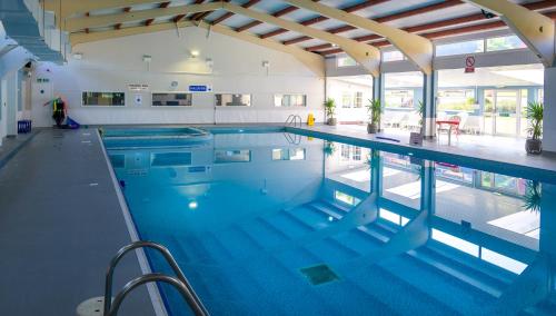 a large swimming pool in a building at Escape to a Clifftop Chalet with pool and tennis onsite - 38 Kingsdown Park in Kingsdown
