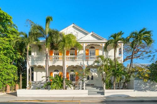 a white house with palm trees in front of it at Marreros Guest Mansion - Adult Only in Key West