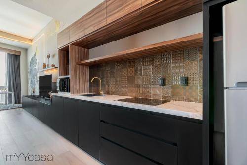 uma cozinha com armários pretos e uma bancada em Luxurious Studio w/ City Views From the 46th Floor em Cidade do México