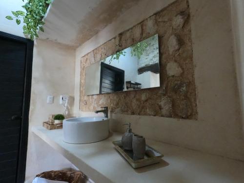 a bathroom with a sink and a mirror on a wall at Bella Casa Colonial González con Piscina in Campeche