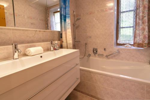 a bathroom with a white tub and a sink and a bath tub at Peter - a87525 in Mittenwald