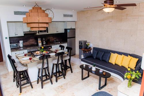 a living room and kitchen with a couch and a table at Maya Villa Condo Hotel and Beachclub in Playa del Carmen
