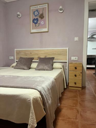 una camera con un grande letto e un comò in legno di Casa Rural CANTONAL a Valencia