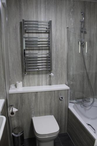 a bathroom with a toilet and a shower and a sink at Cave Castle Hotel in South Cave