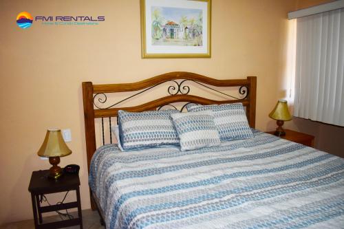 a bedroom with a blue and white bed with two lamps at Marina Pinacate A-520 in Puerto Peñasco