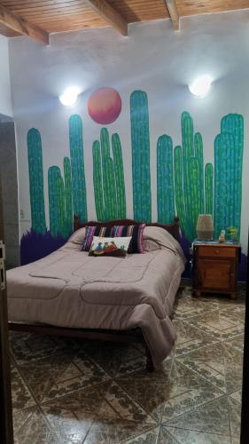 1 dormitorio con 1 cama con un mural de cactus en Casa Norte en Salta