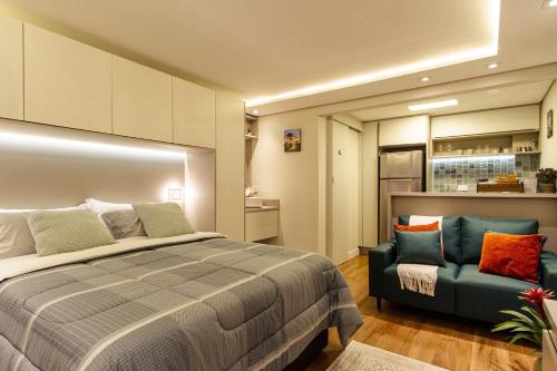 um quarto com uma cama e um sofá em Belvedere em Curitiba