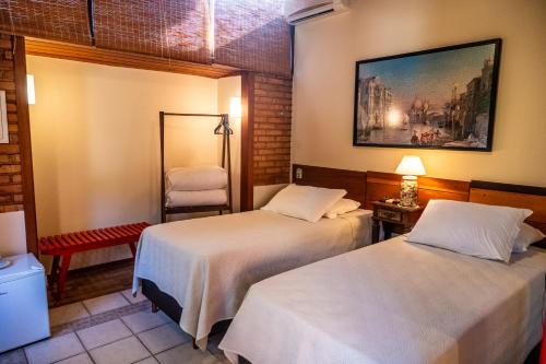 a hotel room with two beds and a mirror at Pousada Mar de Dentro in Florianópolis