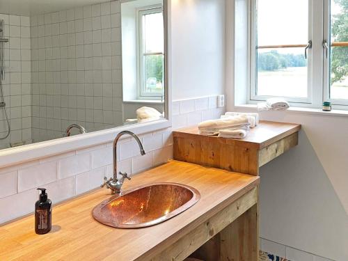 Haddebo的住宿－Holiday home HJORTKVARN III，一间带水槽和镜子的浴室