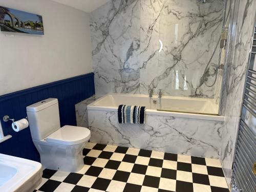 a bathroom with a toilet and a tub and a sink at Artists’ Cottages in Harrogate