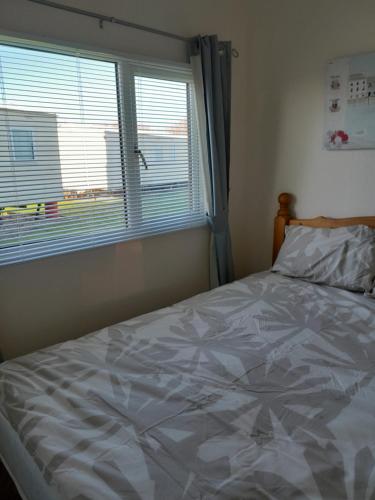 a bedroom with a large bed with a window at B8 lovely chalet in Mablethorpe