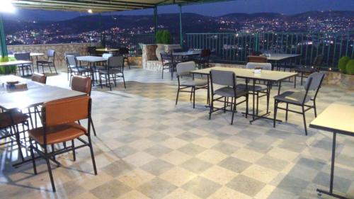 a restaurant with tables and chairs on a roof at Al-jabal castle Hotel - Ajloun in Ajloun