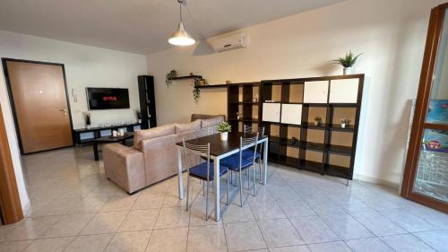 uma sala de estar com um sofá, uma mesa e uma televisão em barby's house em Tortolì