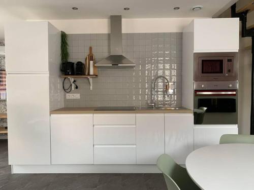 a kitchen with white cabinets and a stove top oven at Maison individuelle in Vincey