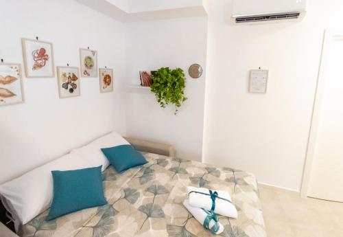 ein weißes Schlafzimmer mit einem Bett mit blauen Kissen in der Unterkunft Liv it - Guest House in Bari