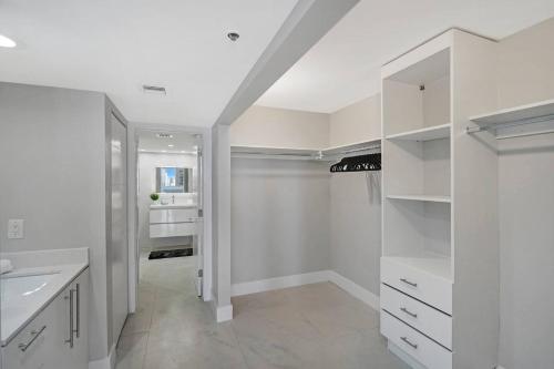 a white kitchen with white counters and white cabinets at Higher Love! Water Views and Cool Vibes in Miami
