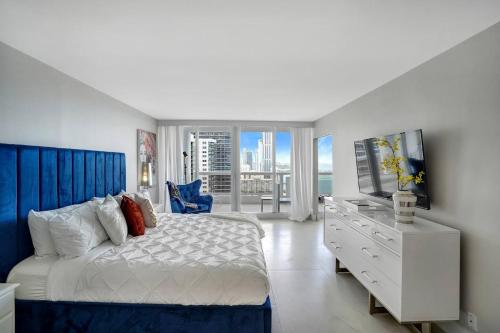 a bedroom with a bed and a dresser with a television at Higher Love! Water Views and Cool Vibes in Miami