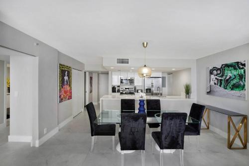 a dining room and kitchen with a glass table and chairs at Higher Love! Water Views and Cool Vibes in Miami