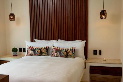 a bedroom with a large white bed with two pillows at Maya Villa Condo Hotel and Beachclub in Playa del Carmen