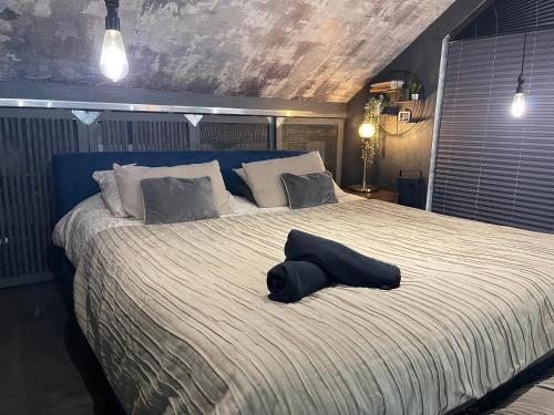 uma cama grande com uma almofada em cima em Unique and Artsy Holiday Shared Home em Purley