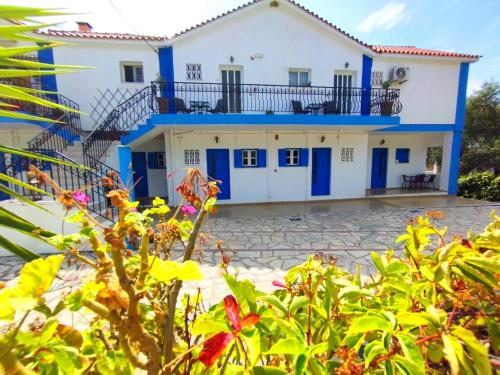 a house with blue doors and a yard with plants at spasmata houses in Minia