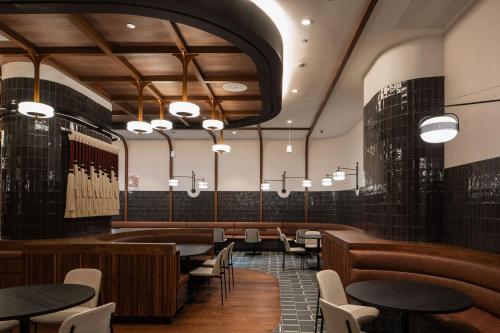 a dining room with tables and chairs and chandeliers at Motto By Hilton New York City Times Square in New York