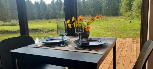 a table with two plates and a vase of flowers at Puhkemaja metsa sees in Urvaste