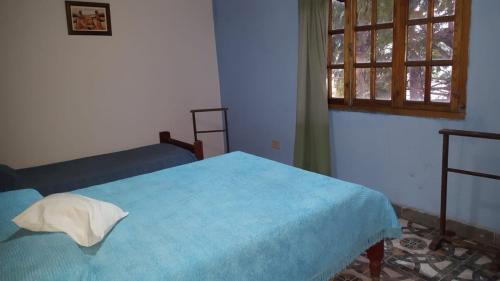 a bedroom with a blue bed and a window at Casa Norte in Salta