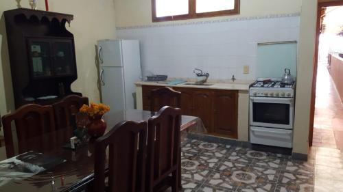 Casa Norte في سالتا: مطبخ مع ثلاجة وطاولة مع كراسي