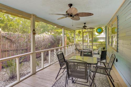 a screened porch with tables and chairs and a ceiling fan at Lake Wales Vacation Rental with Screened-In Porch! in Lake Wales