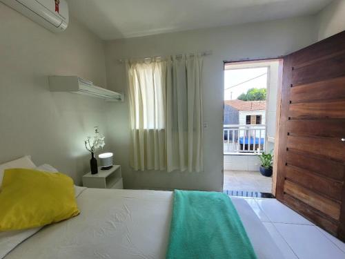 a bedroom with a bed and a large window at Teto Hospedagens in Fortaleza