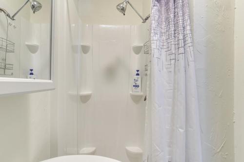 ein Bad mit einer Dusche mit einem weißen Duschvorhang in der Unterkunft Cozy Norman Studio Walk to OU and Campus Corner! in Norman