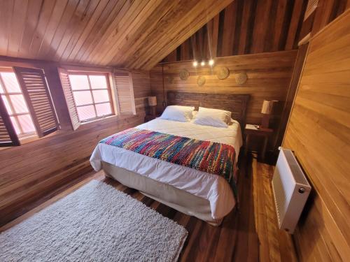 a bedroom with a bed in a wooden cabin at ALMA CHILOTA in Castro