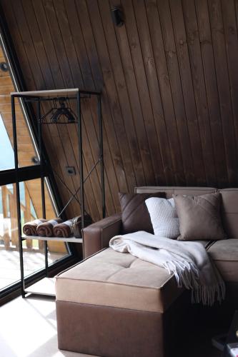 un sofá en una habitación con una pared de madera en UkhutiEcoHouse, en Vani