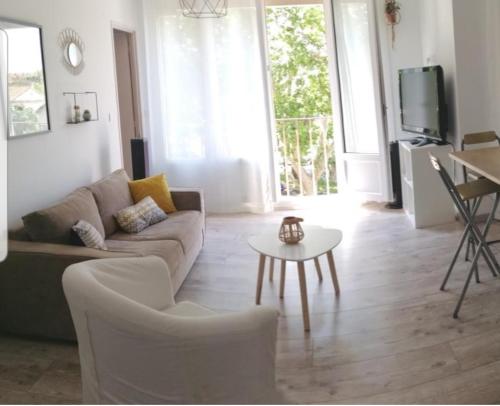 sala de estar con sofá y mesa en Joli trois chambres première ceinture Avignon en Aviñón