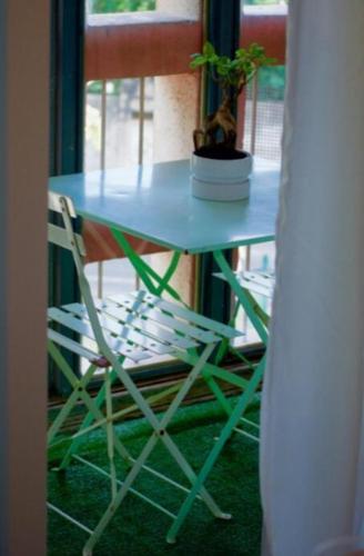 una mesa azul y una silla con una planta. en Joli trois chambres première ceinture Avignon en Aviñón