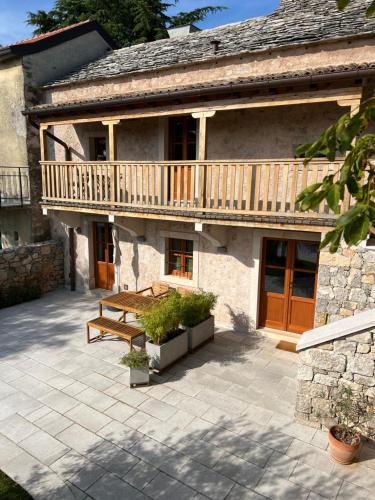 a house with a wooden deck and a patio at Appartamenti Minerva in San Pelagio