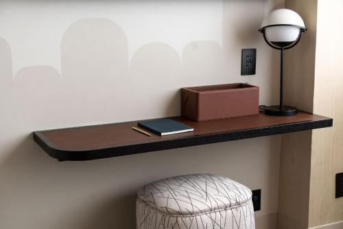 a shelf on a wall with a lamp and a stool at Motto By Hilton New York City Times Square in New York