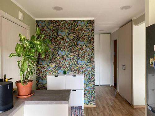 a room with a plant and a wall with a wallpaper at Apartments in Valmiera in Valmiera