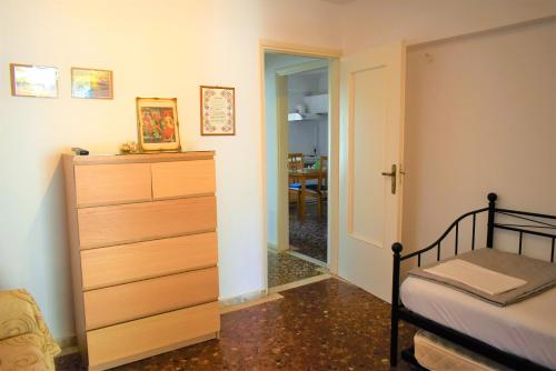 a bedroom with a bed and a dresser next to a door at Gianna Seaside in Koutsounari
