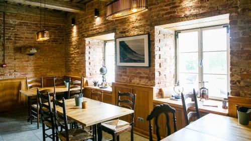 a restaurant with wooden tables and chairs and a brick wall at Ungru Guesthouse in Suuresadama