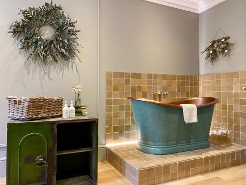 a bathroom with a large tub on a tiled wall at Railway House York by Chateau Anna in York