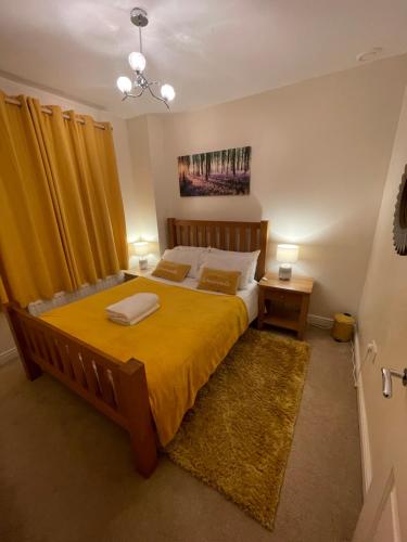 um quarto com uma cama grande e uma colcha amarela em Holiday Home In Cardiff. Sleeps 6 em Cardiff
