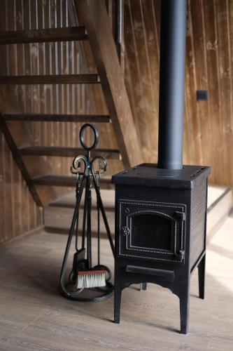 a black stove in a room next to a staircase at UkhutiEcoHouse in Vani