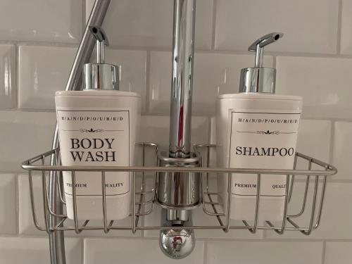 a shelf with two bottles of body wash and shannon at Le 25, Duplex élégant au cœur du piétonnier historique in Namur